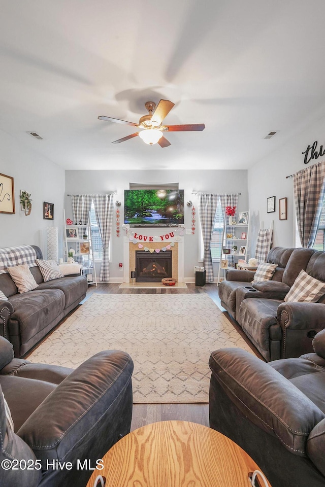 living area with a wealth of natural light, visible vents, and a fireplace with flush hearth