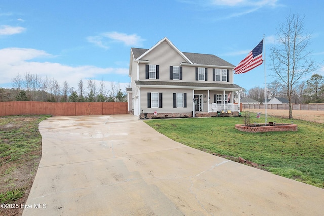 view of front of home with a porch, concrete driveway, fence, and a front yard