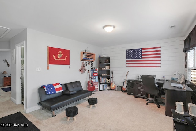 home office featuring attic access, visible vents, wood walls, and light carpet