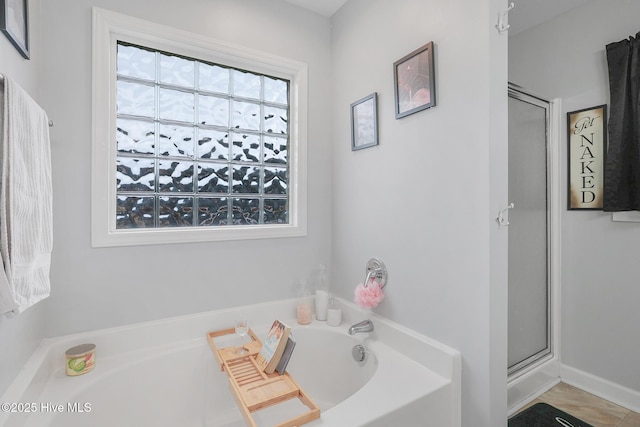 full bath with a stall shower and a garden tub