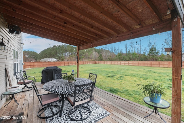 wooden terrace featuring area for grilling, a lawn, outdoor dining area, and a fenced backyard