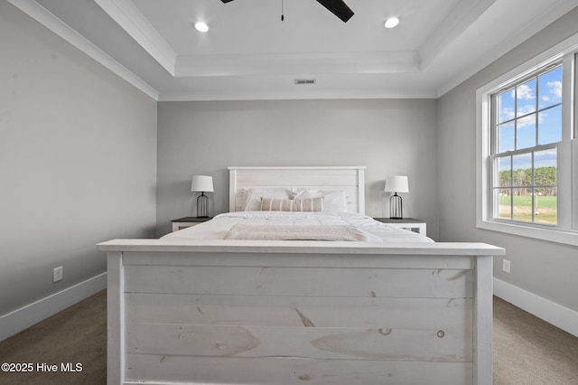 bedroom featuring baseboards, dark carpet, and a raised ceiling