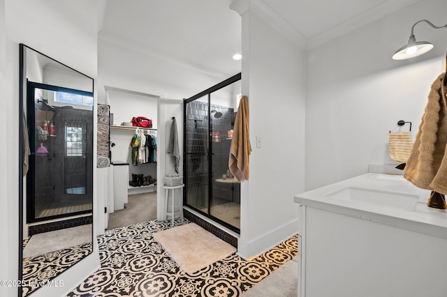 bathroom featuring a stall shower, baseboards, a walk in closet, and crown molding