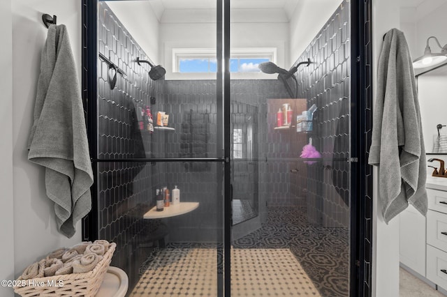 bathroom with ornamental molding and tiled shower