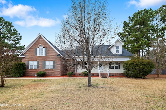 view of front of property featuring a front yard, a porch, brick siding, and crawl space