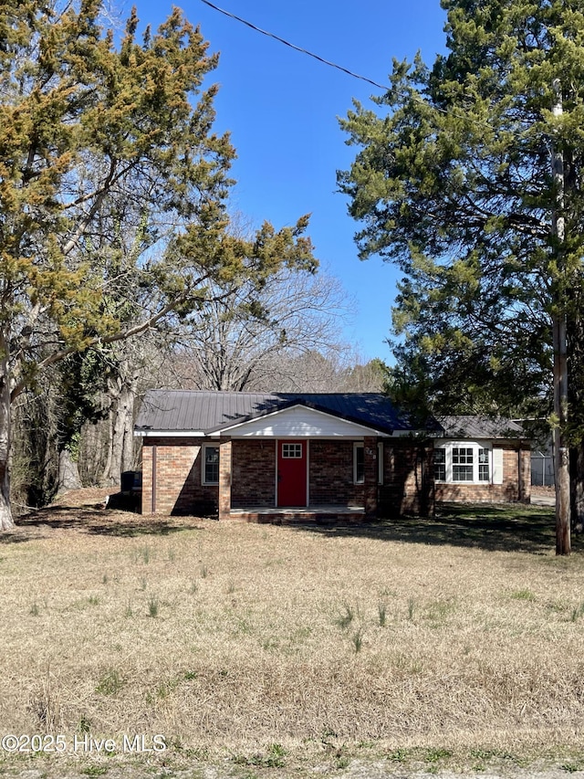 view of front of house with metal roof and a front lawn