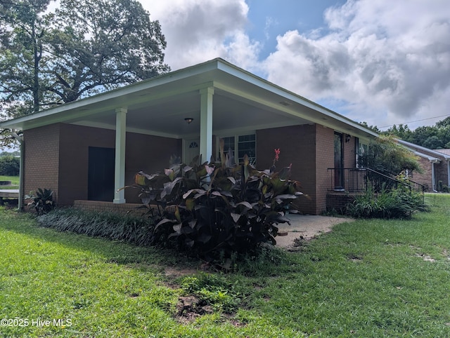 13596 Hobbton Hwy, Newton Grove, NC 28366 - view of side of home with brick siding, a lawn, and an attached carport