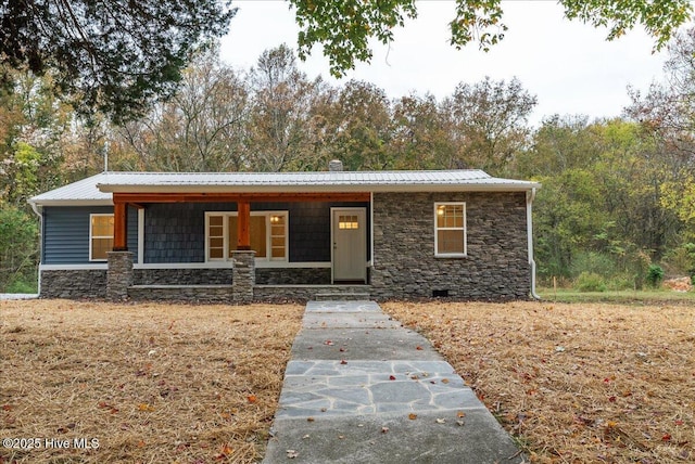 view of front of home featuring crawl space, stone siding, and metal roof