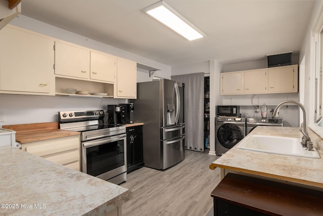 kitchen featuring a sink, washer and clothes dryer, light countertops, appliances with stainless steel finishes, and open shelves