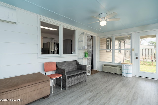 sunroom / solarium featuring ceiling fan and a wall unit AC