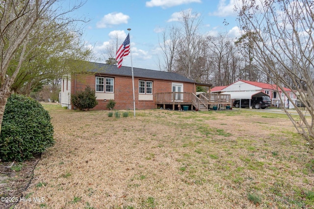 rear view of house with crawl space, a wooden deck, a lawn, and brick siding