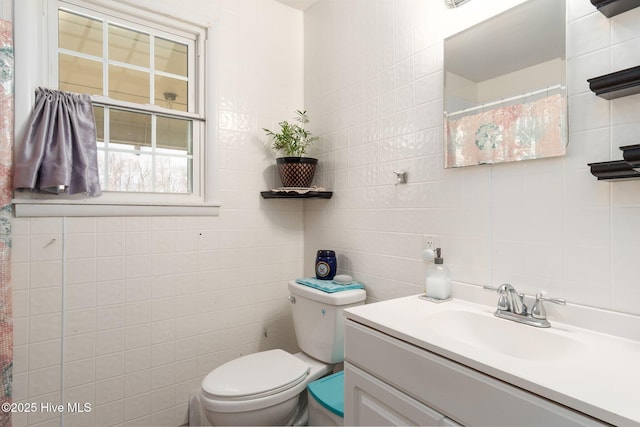 full bath featuring toilet and tile walls