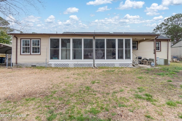 back of house with a carport, central AC unit, a lawn, a sunroom, and crawl space