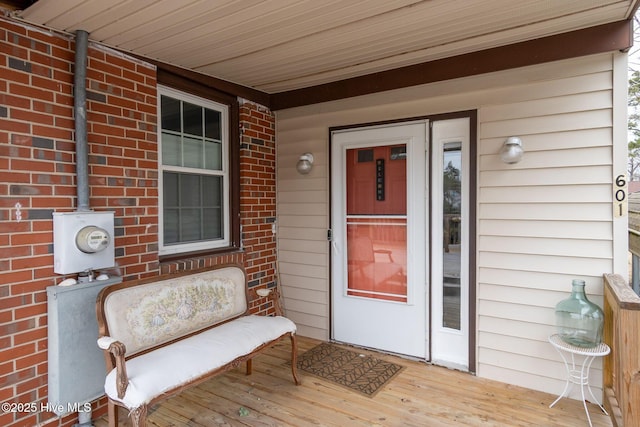 property entrance featuring brick siding and a porch