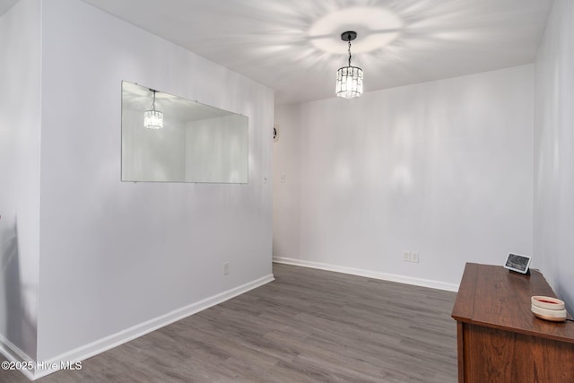 empty room with baseboards and wood finished floors