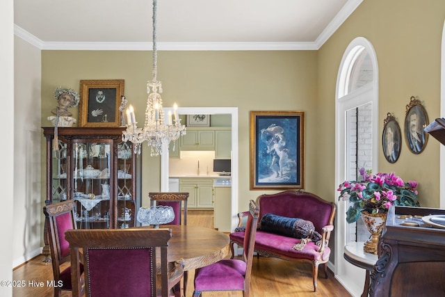 dining area featuring crown molding, wood finished floors, and a chandelier