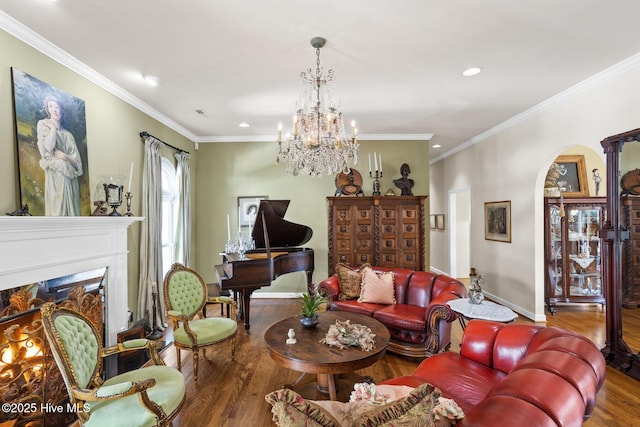 living room featuring wood finished floors, baseboards, a premium fireplace, arched walkways, and ornamental molding