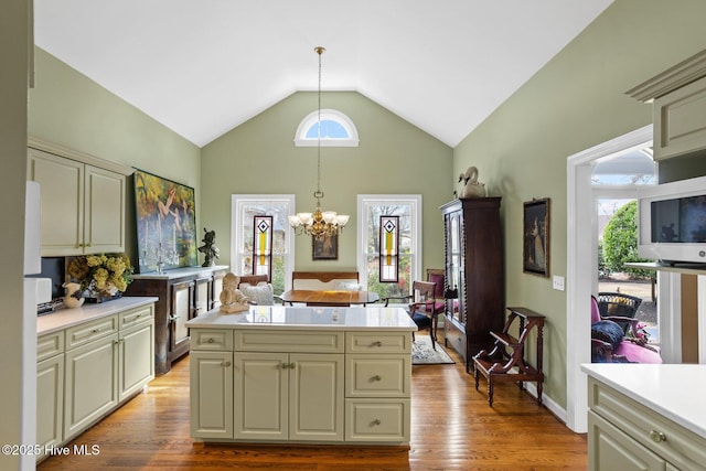 kitchen with a kitchen island, wood finished floors, hanging light fixtures, and light countertops