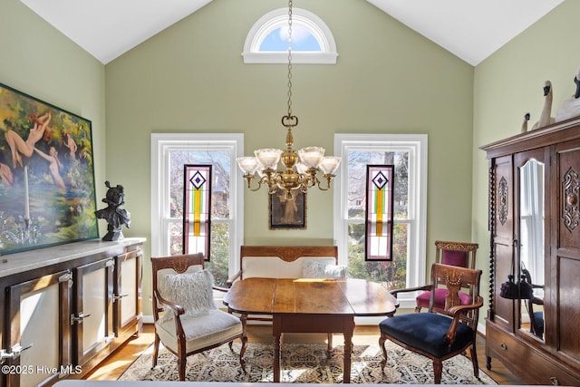 dining room featuring high vaulted ceiling, a wealth of natural light, and a chandelier