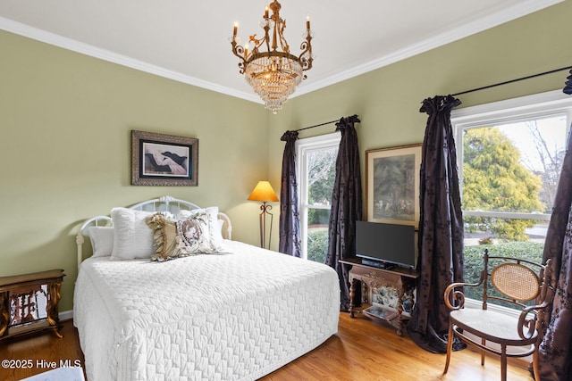 bedroom featuring a notable chandelier, wood finished floors, and ornamental molding