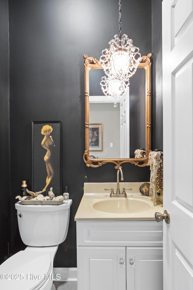 bathroom featuring a chandelier, toilet, and vanity