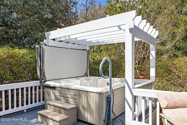 wooden deck featuring a pergola and a hot tub