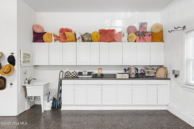 kitchen featuring white cabinetry and dark countertops