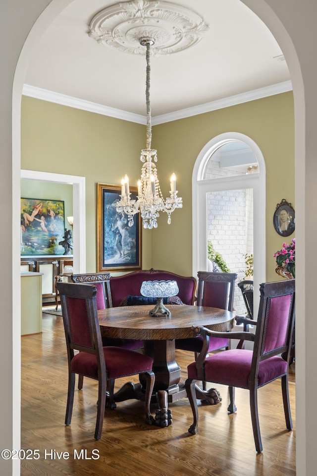 dining space featuring crown molding and wood finished floors