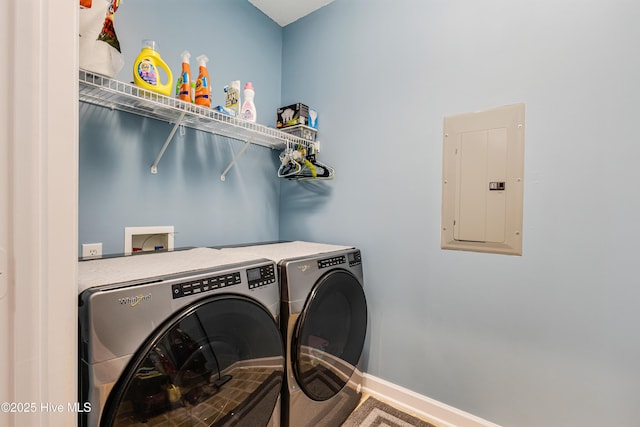 laundry area featuring laundry area, electric panel, washer and clothes dryer, and baseboards