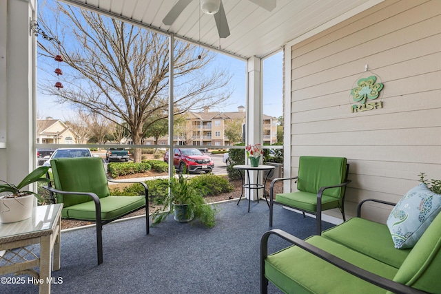 sunroom / solarium featuring a residential view and ceiling fan