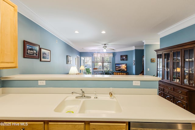 kitchen featuring ceiling fan, a sink, light countertops, dishwasher, and crown molding