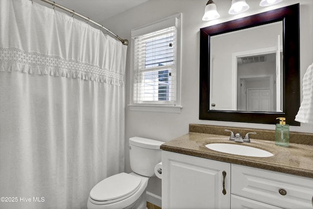 bathroom with vanity, toilet, and visible vents