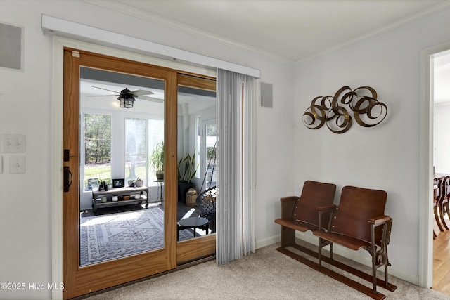 entryway with crown molding, a ceiling fan, baseboards, and carpet floors