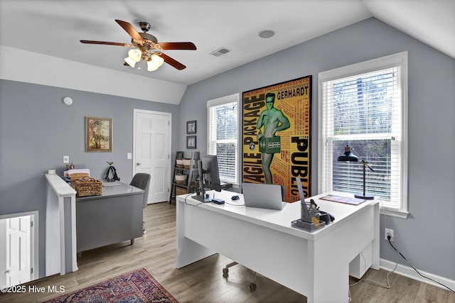 office with visible vents, baseboards, ceiling fan, vaulted ceiling, and light wood-style flooring