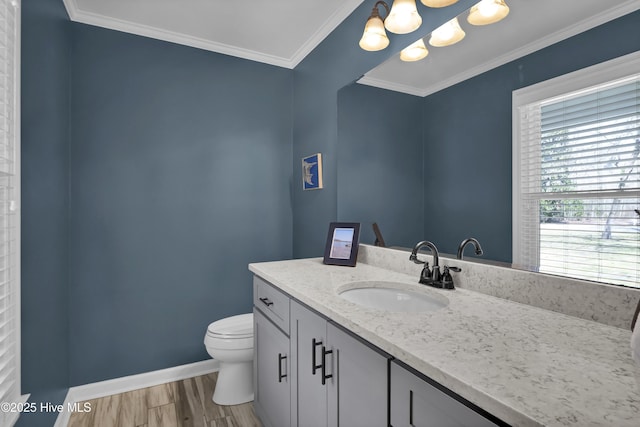 bathroom with vanity, wood finished floors, baseboards, ornamental molding, and toilet