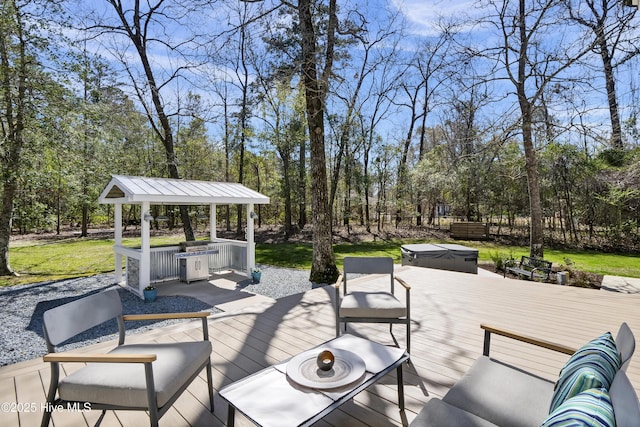 wooden deck featuring a gazebo, an outdoor living space, grilling area, and a covered hot tub