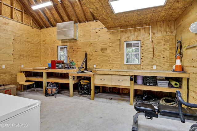 miscellaneous room featuring a workshop area, concrete flooring, and vaulted ceiling