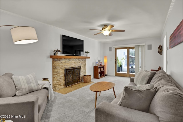 carpeted living area featuring a stone fireplace, crown molding, and ceiling fan