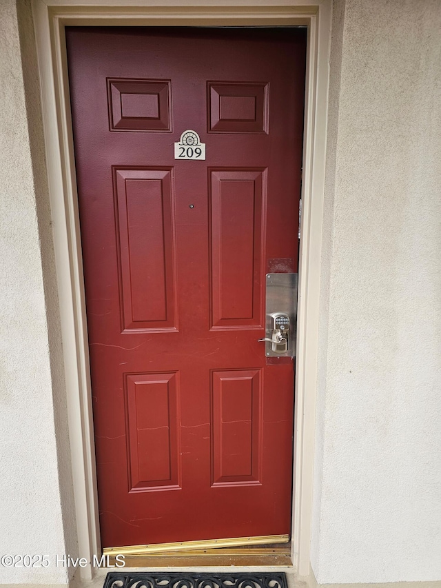 doorway to property featuring stucco siding