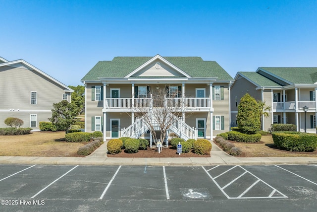 view of property featuring stairs and uncovered parking