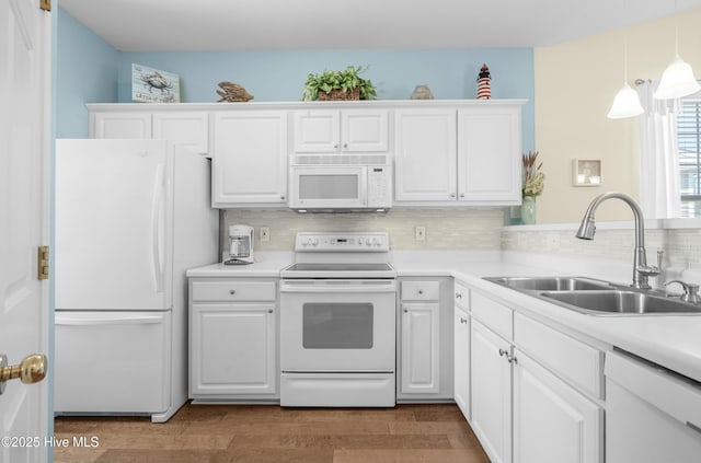 kitchen featuring decorative backsplash, white cabinetry, a sink, wood finished floors, and white appliances