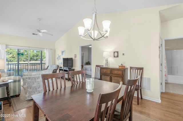 dining area with visible vents, light wood-style floors, high vaulted ceiling, baseboards, and ceiling fan with notable chandelier