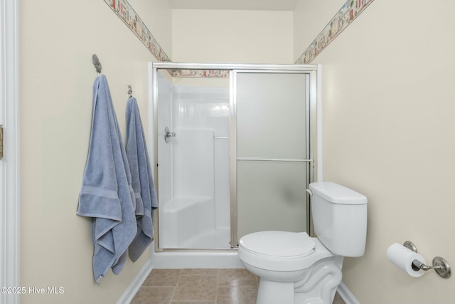 bathroom featuring a shower stall, toilet, and tile patterned floors