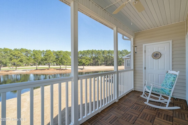 sunroom with a water view and a ceiling fan