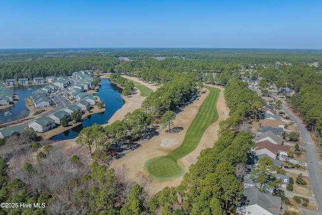 drone / aerial view featuring a water view, golf course view, and a wooded view