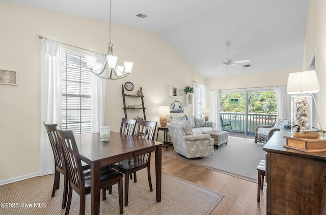 dining room featuring visible vents, vaulted ceiling, light wood finished floors, and ceiling fan with notable chandelier