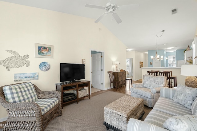 living room with ceiling fan with notable chandelier, high vaulted ceiling, and visible vents