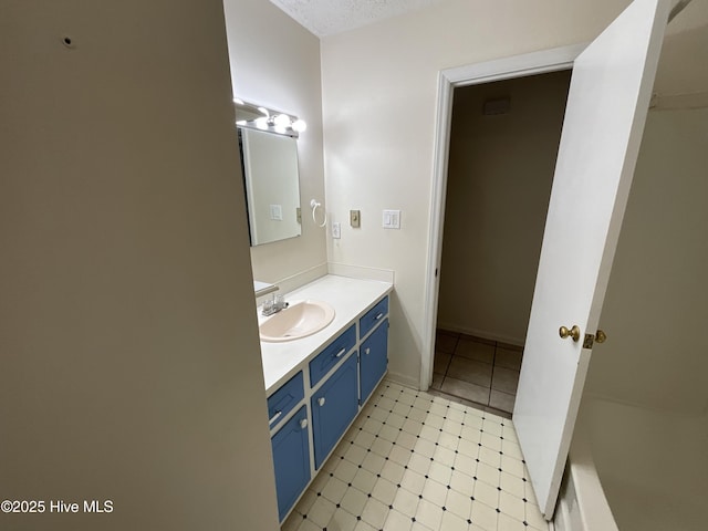 full bath featuring a textured ceiling and vanity