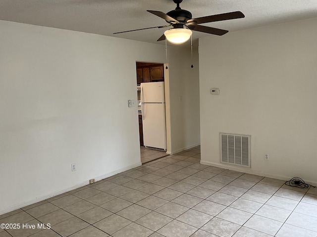 spare room featuring baseboards, visible vents, a textured ceiling, and a ceiling fan