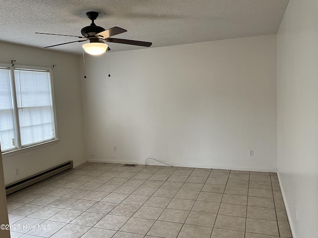 spare room with a textured ceiling, light tile patterned flooring, visible vents, and a baseboard radiator